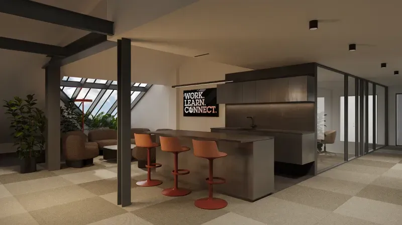 Kitchen lounge with an island, orange bar stools, armchairs and a “Work. Learn. Connect.” sign.